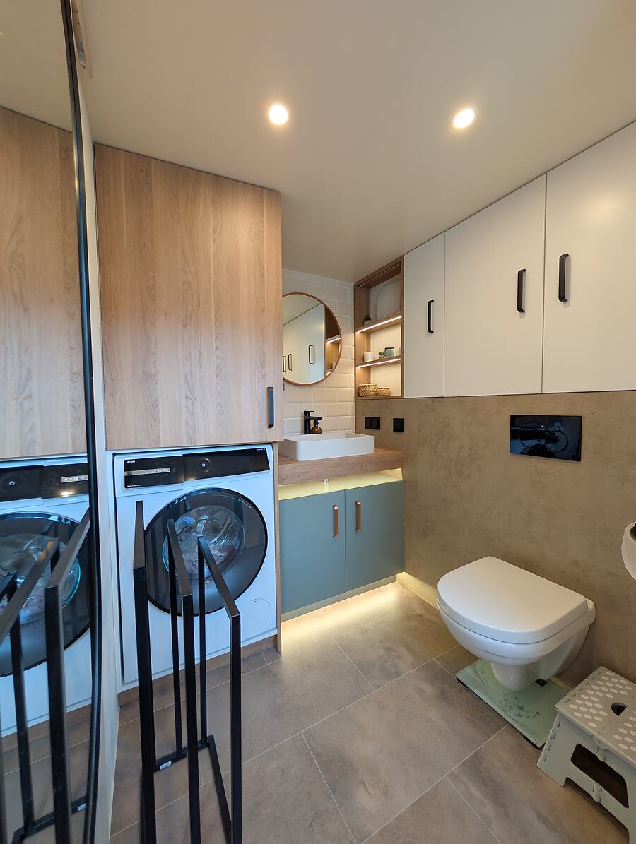 Badezimmer mit Waschmaschine und Toilette